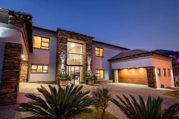 A vertically draped chandelier adds some drama to the entry, while the inground pool wrapped in frameless glass is without a doubt the ...