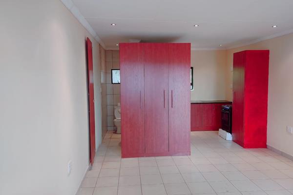 1 bedroom with build in wardrobes .

A toilet and shower .

Kitchen with stove and ...