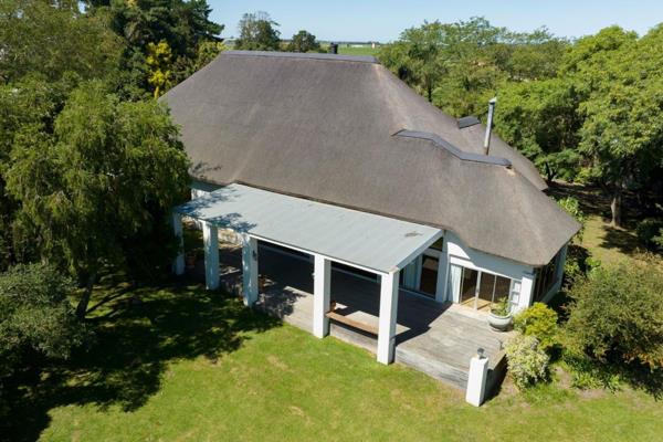 At the end of a paved driveway lies this north facing thatched home. The tree filled garden faces the Outeniqua Mountain Range with a ...