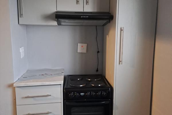 The unit is neat and tiled throughout.
The kitchen has a 4 plate stove with extractor fan and built-in cupboards.

The bathroom ...