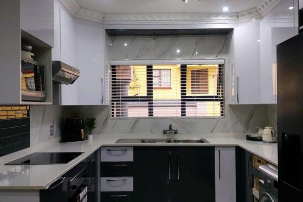 Main ensuite with walk in closet.
Study with bookshelves.
Gloss kitchen with Caesarstone tops.
Open plan living and dining ...