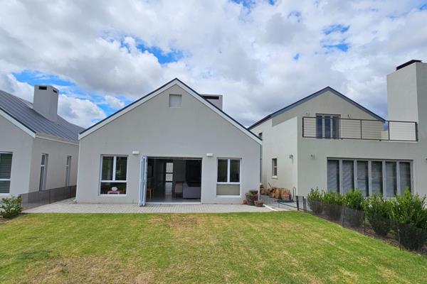 Discover modern luxury living at Silwerstrand Golf Estate in this single-level home ...