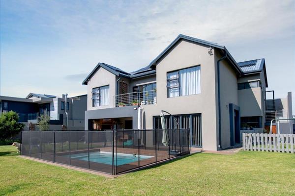 The front of the home is appealing, with clean lines. The modern front facade has glass panels overlooking a beautiful garden making it ...