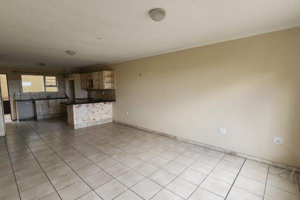 Features:

Spacious, open-plan living area with tiled flooring.
Large windows providing ample natural light.
Modern kitchen with ...