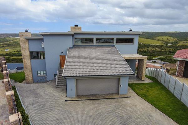This modern 3-bedroom home with 2 garages and a picturesque view embodies contemporary ...
