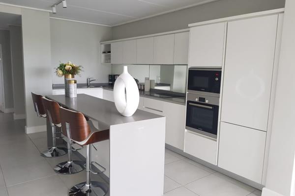 This luxurious open-plan apartment offers an expansive kitchen fitted with an integrated ...