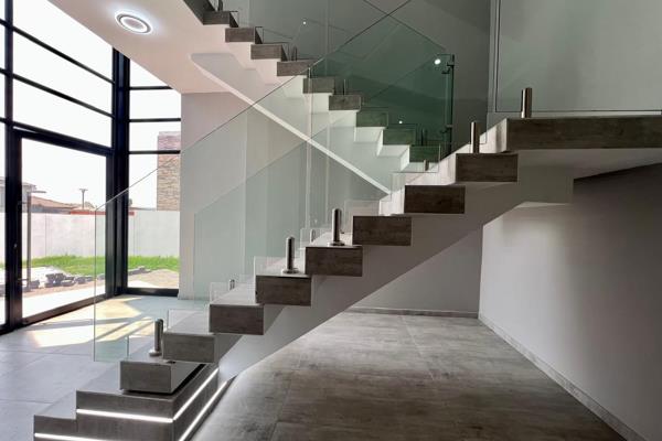 - Magnificent entrance with floating staircase, showcasing raw concrete and glass.
- Study on ground floor with private entrance.
- ...