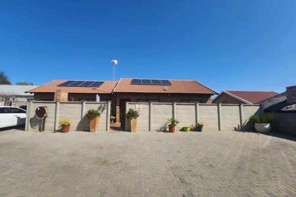 A 3-bedroom townhouse with 2 bathrooms, an open-plan lounge and wooden kitchen, an entertainment area with a built-in braai, a single ...