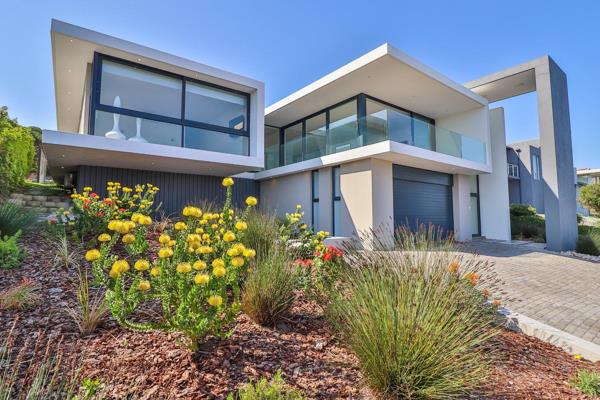 Step through the expansive glass door into a high-ceilinged entrance hall, featuring ...