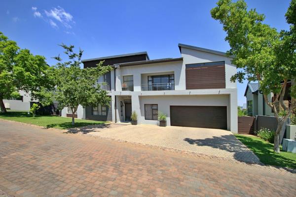 From the double automated garage, a paved driveway leads to a charming stepping-stone walkway that guides you to the large ...