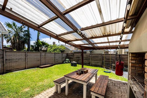 This townhouse offers an open plan living area with with a sliding door that opens to a covered patio with built-in braai and private ...