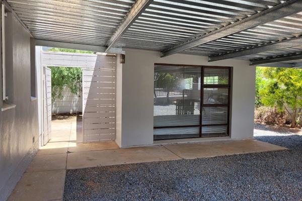 This neat flat features an open plan kitchen with built in cupboards and a washing ...