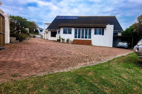 The large, covered veranda with built-in braai is the heart and entrance to this unique ...