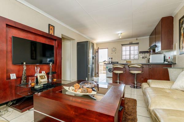 This 2-bedroom townhouse features a fully tiled kitchen, a spacious lounge, a full ...