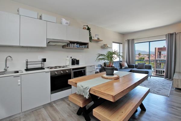 Modern top-floor apartment with balcony. 
Open-plan contemporary kitchen with electric ...