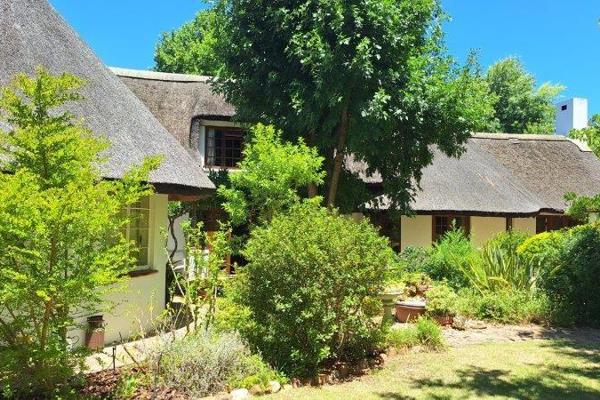 This unusual property has all the charm of a country village, with many old trees and garden nooks.
The house is a thatch rondawel ...