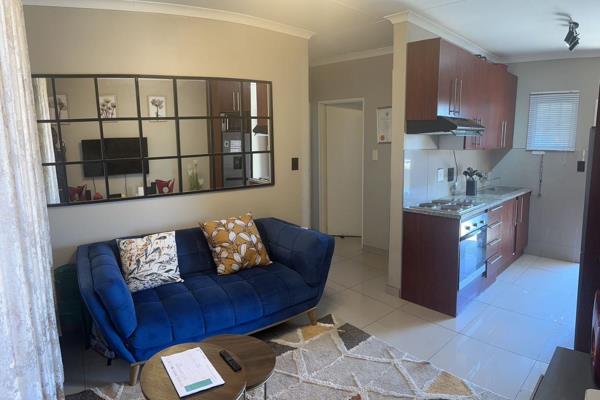 This lovely unit offers a bright and open living space, with a neat kitchen featuring ...