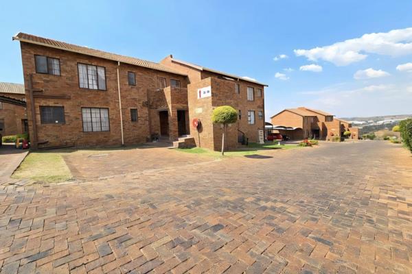 This neat upper floor unit features an open plan lounge, dining area and kitchen with ...