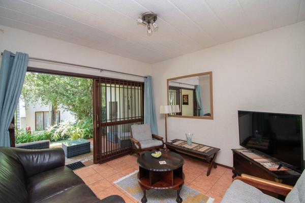 Open plan Dining Room and Lounge with large sliding door onto covered Patio with a built in braai and views of the stunning gardens.  ...
