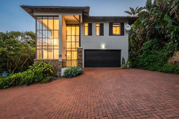 This beautifully designed home immediately impresses with a striking glass facade that ...
