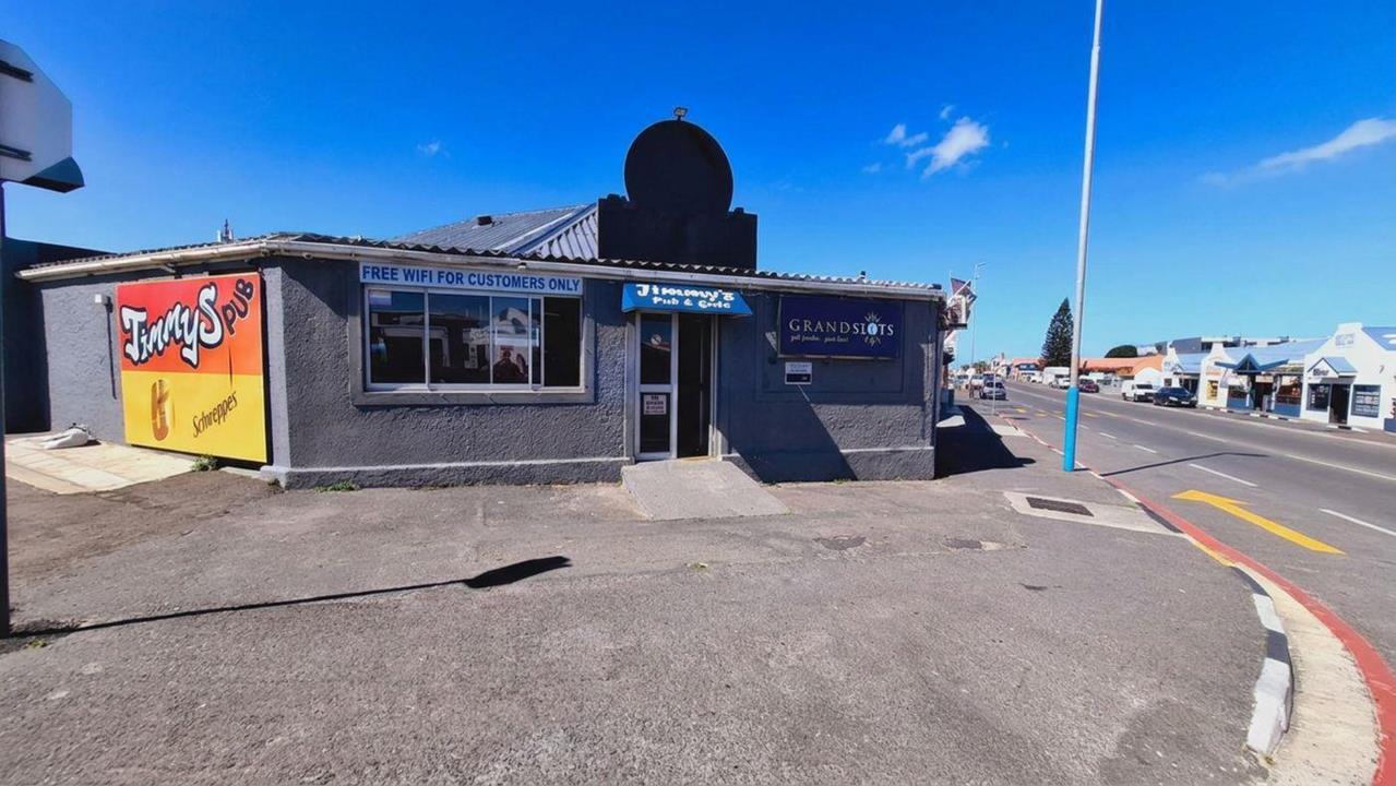 Listing number: P24-117680027, Image number: 1, The pub on its street corner: a Jimmy's Pub sign on the side wall, the pub's sign over the door and the Grandslots sign beside it, and the road running on past the town's shops